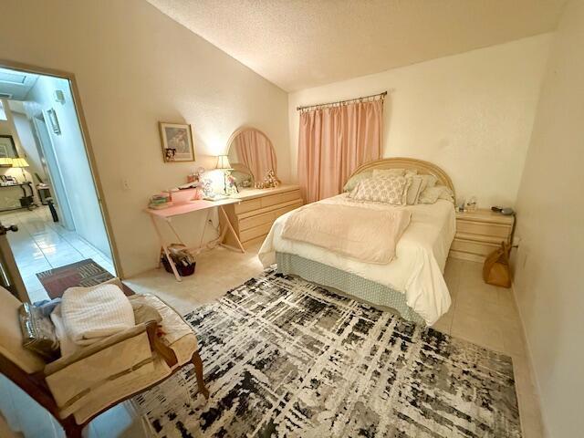 tiled bedroom featuring a textured ceiling