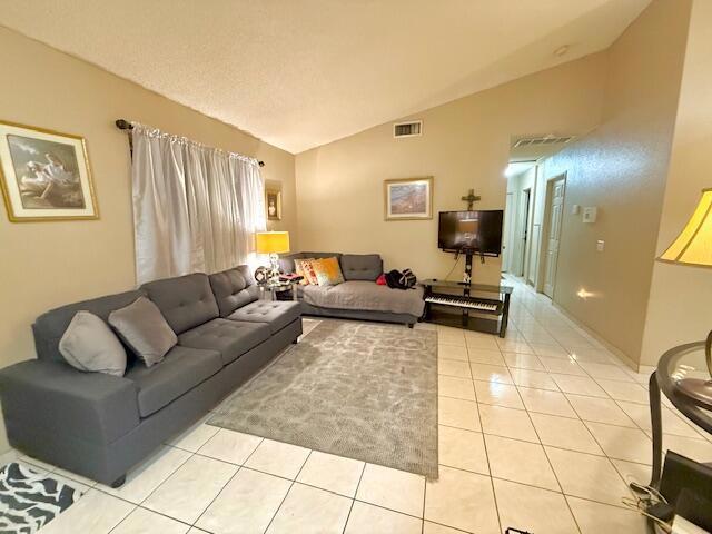 tiled living room featuring lofted ceiling