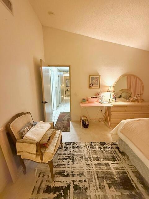 bedroom featuring a textured ceiling and lofted ceiling