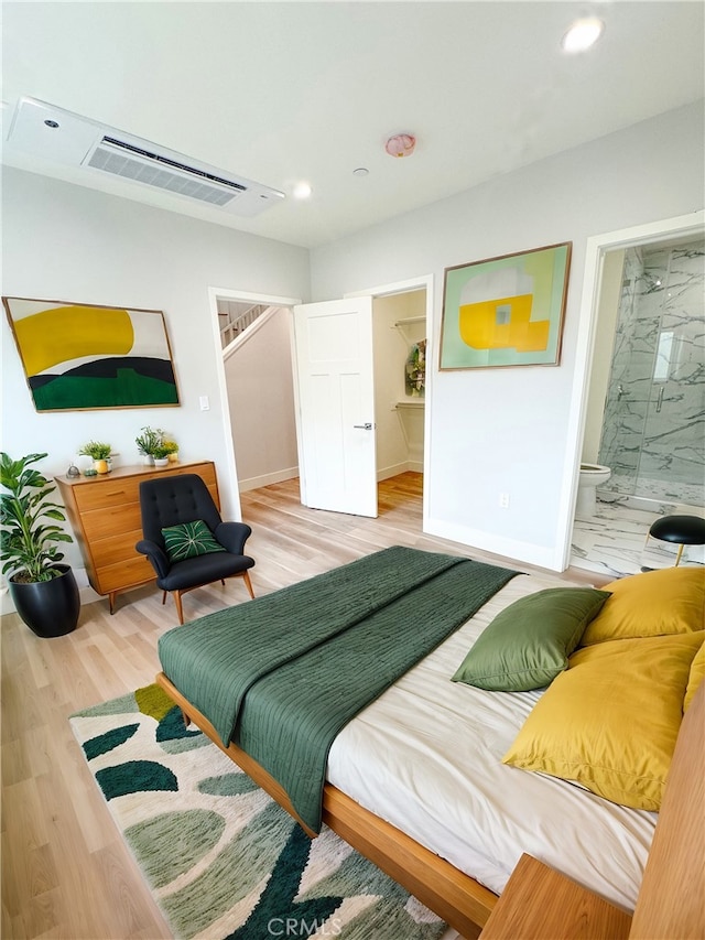 bedroom with wood-type flooring and ensuite bathroom