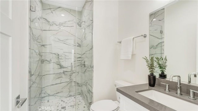 bathroom featuring vanity, toilet, and a shower with shower door