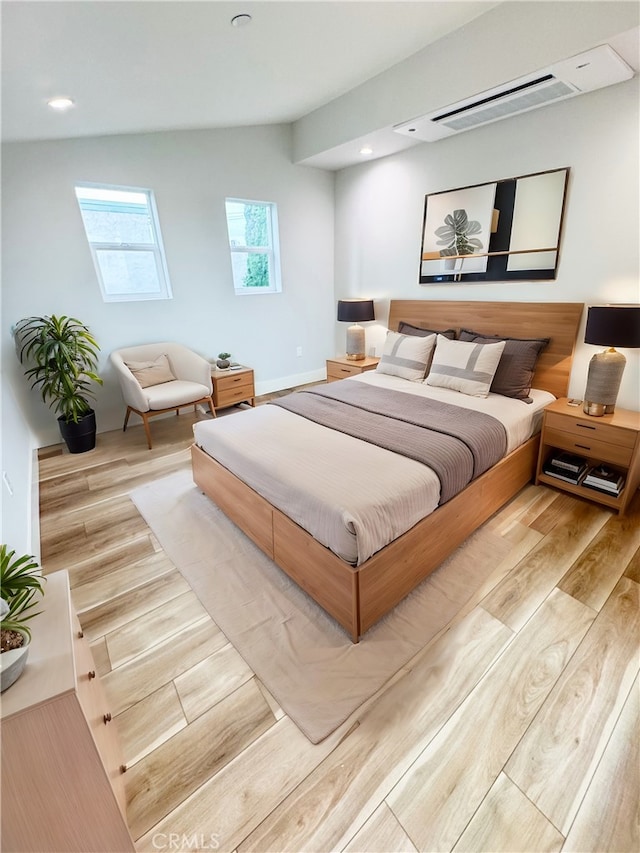 bedroom featuring light hardwood / wood-style floors and lofted ceiling