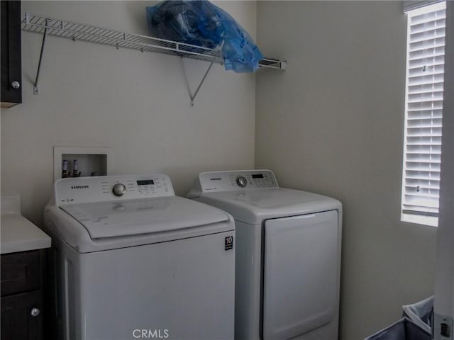 laundry room featuring washing machine and dryer and cabinets