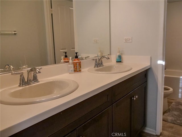 bathroom with hardwood / wood-style floors, vanity, and toilet