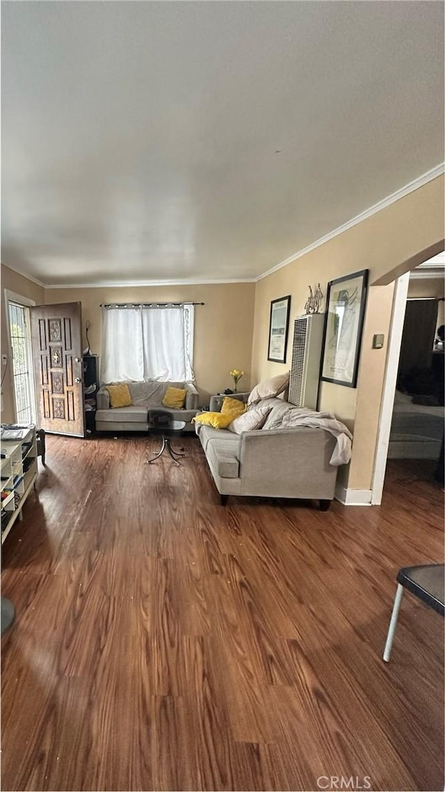 unfurnished living room featuring wood-type flooring and crown molding