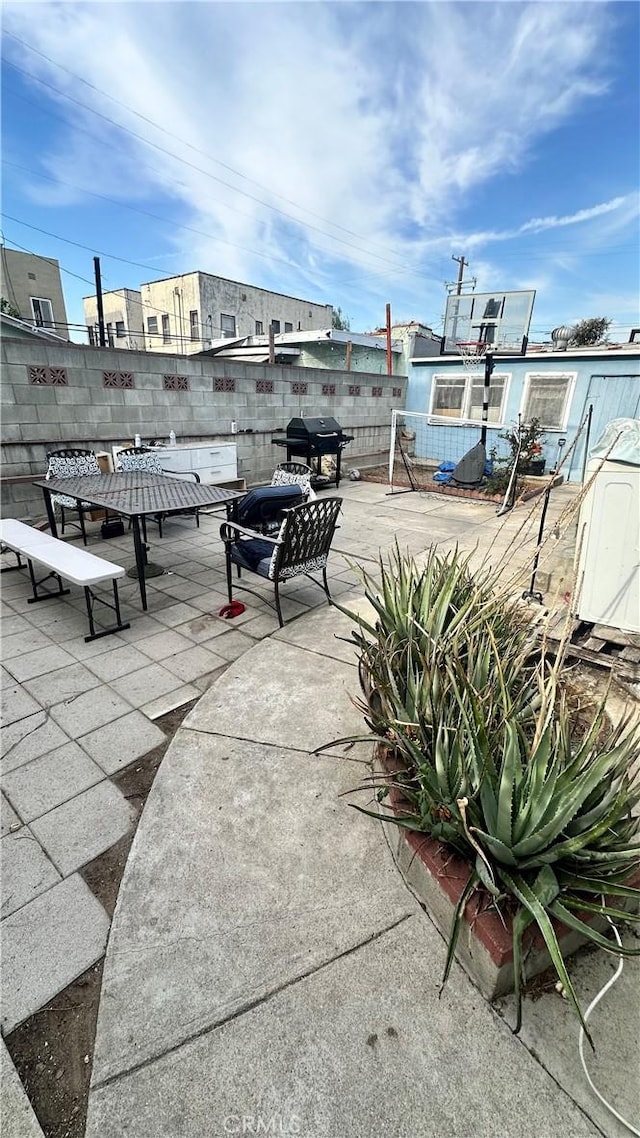 view of patio featuring a storage unit and grilling area