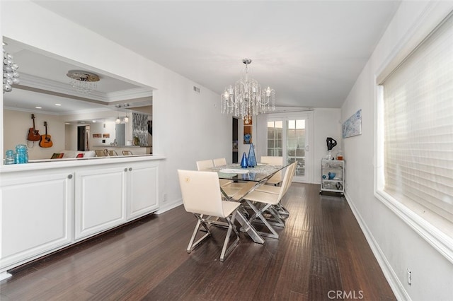 dining room featuring dark hardwood / wood-style floors, an inviting chandelier, and crown molding