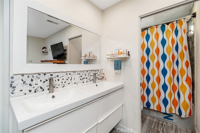 bathroom featuring tasteful backsplash, vanity, and wood-type flooring