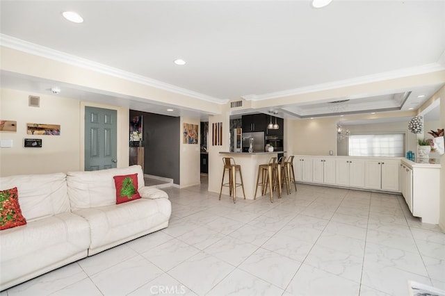 living room featuring a raised ceiling and ornamental molding