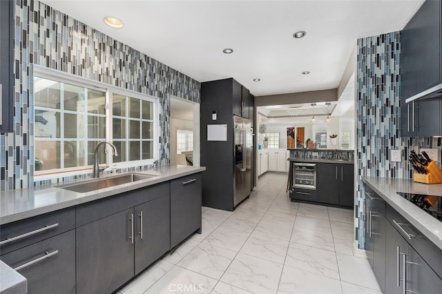 kitchen with stainless steel fridge with ice dispenser, sink, beverage cooler, and a healthy amount of sunlight