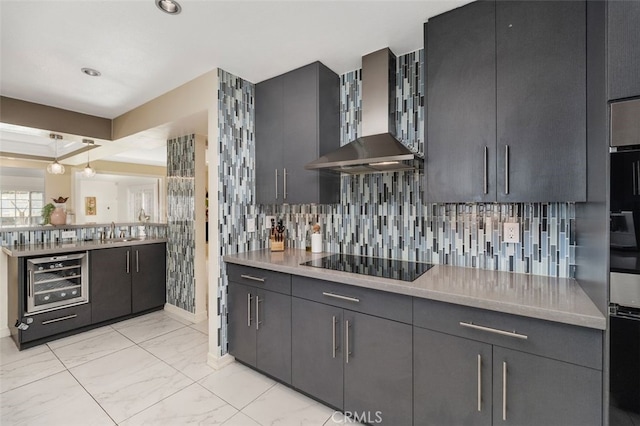 kitchen featuring beverage cooler, wall chimney range hood, tasteful backsplash, pendant lighting, and black electric stovetop