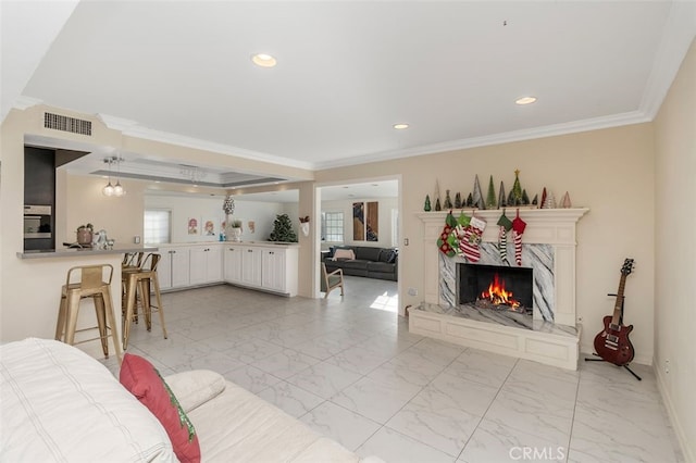 living room with a fireplace, plenty of natural light, and ornamental molding