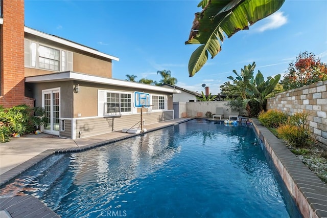 view of swimming pool featuring pool water feature and a patio