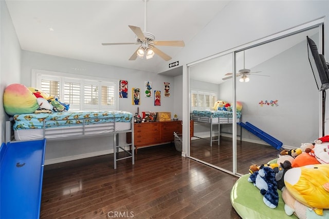 bedroom with dark hardwood / wood-style flooring, ceiling fan, a closet, and vaulted ceiling