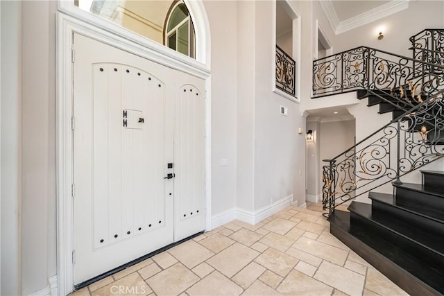 foyer featuring crown molding and a high ceiling