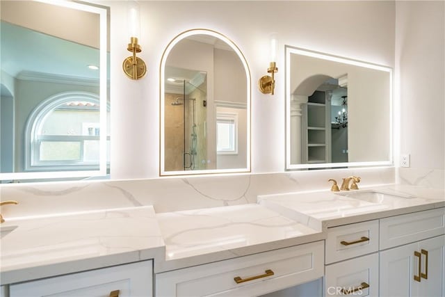 bathroom with plenty of natural light, vanity, ornamental molding, and walk in shower