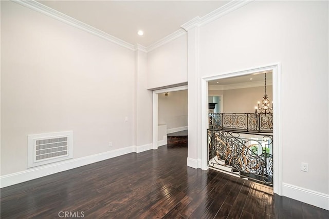 empty room featuring a notable chandelier, ornamental molding, dark wood-type flooring, and a high ceiling