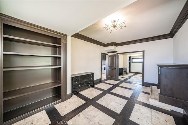 unfurnished living room with a chandelier, washer / clothes dryer, and ornamental molding