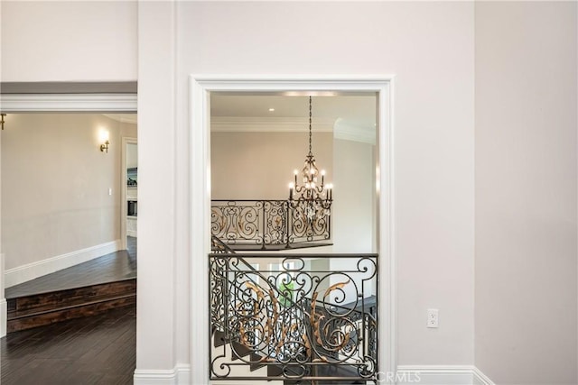 details featuring crown molding, wood-type flooring, and a notable chandelier