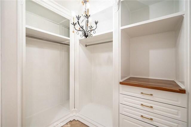 spacious closet with a chandelier