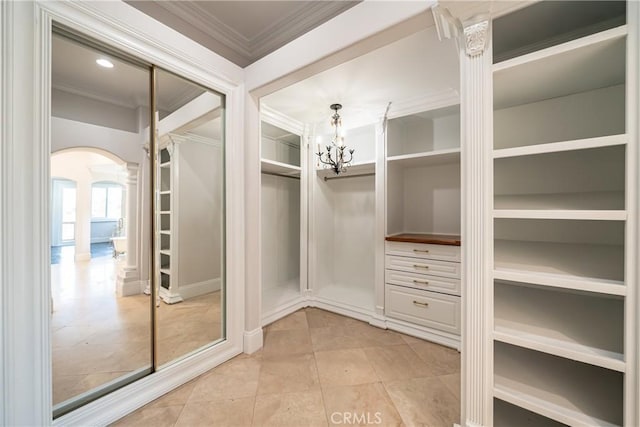 walk in closet featuring light tile patterned flooring and a chandelier