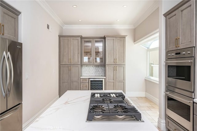 kitchen with decorative backsplash, light stone counters, ornamental molding, stainless steel appliances, and beverage cooler