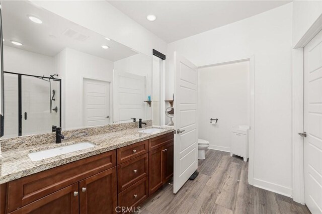 bathroom featuring walk in shower, toilet, vanity, and hardwood / wood-style flooring