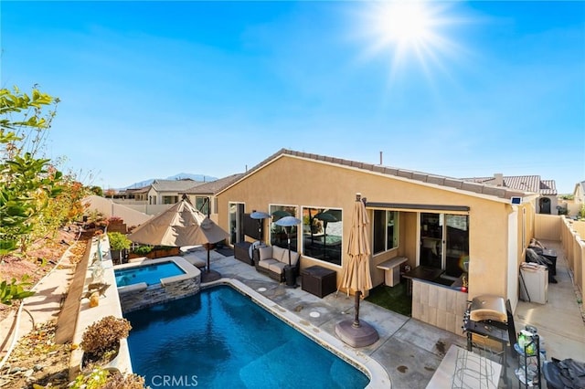 view of swimming pool featuring a patio area, a fenced backyard, and a pool with connected hot tub