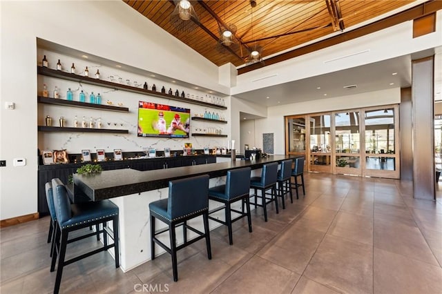 bar featuring ceiling fan, wood ceiling, and lofted ceiling