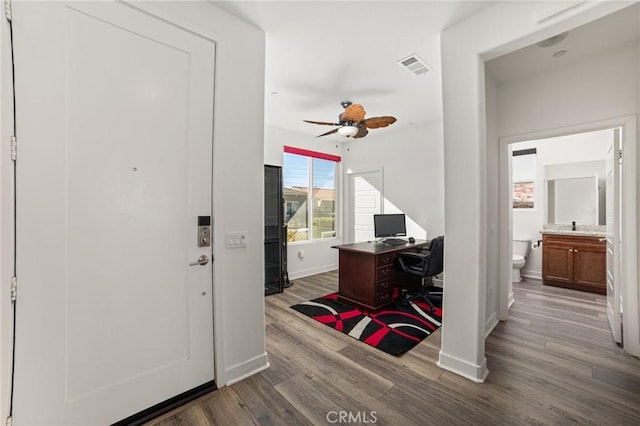 office area with visible vents, ceiling fan, baseboards, and wood finished floors