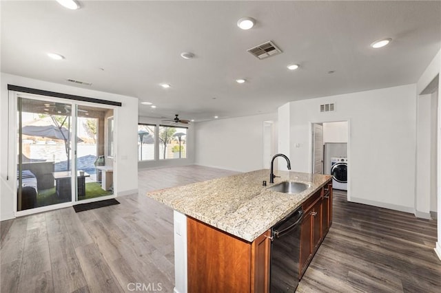 kitchen with washer / dryer, black dishwasher, visible vents, and a sink