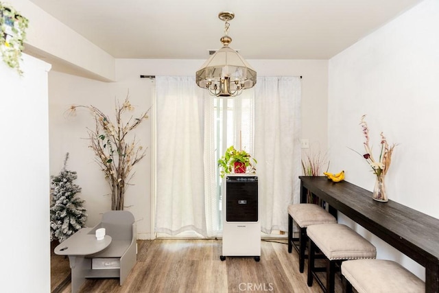 dining area featuring wood-type flooring and an inviting chandelier