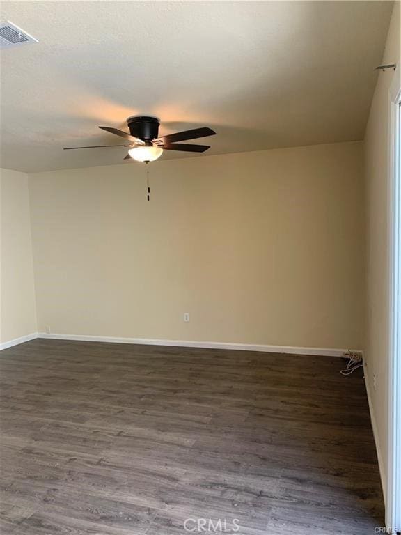 spare room featuring dark hardwood / wood-style flooring and ceiling fan