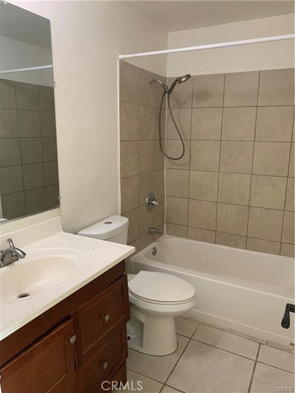 full bathroom with vanity, tile patterned floors, toilet, and tiled shower / bath