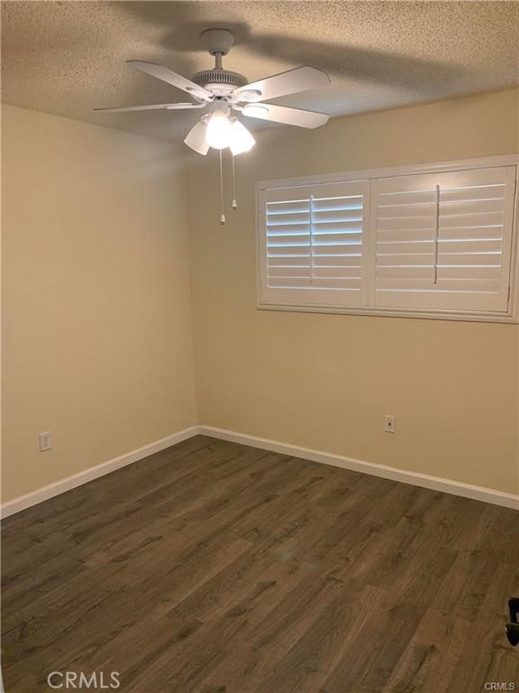 unfurnished room with ceiling fan, dark hardwood / wood-style floors, and a textured ceiling