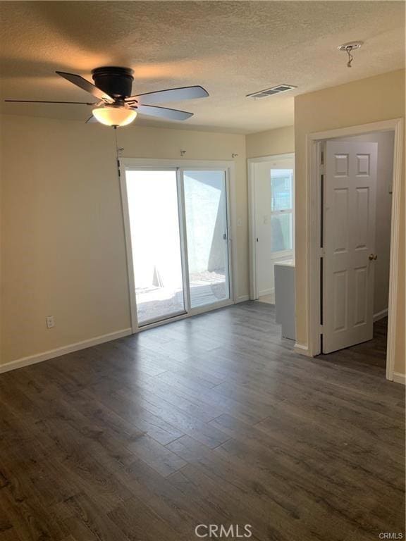 spare room featuring ceiling fan, dark hardwood / wood-style floors, and a textured ceiling