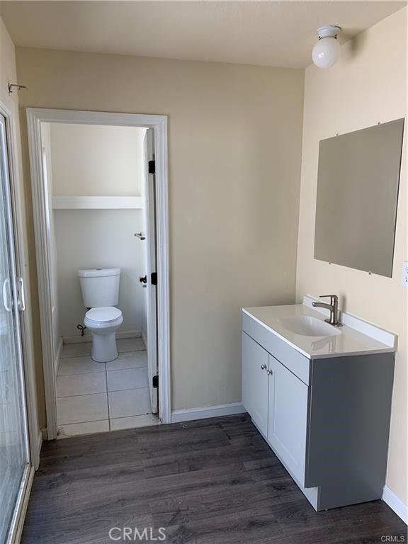 bathroom with vanity, hardwood / wood-style flooring, and toilet