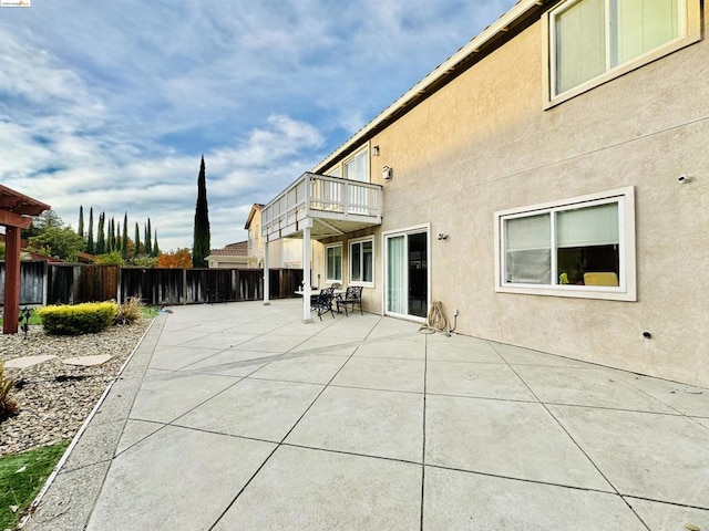 back of property with a balcony and a patio