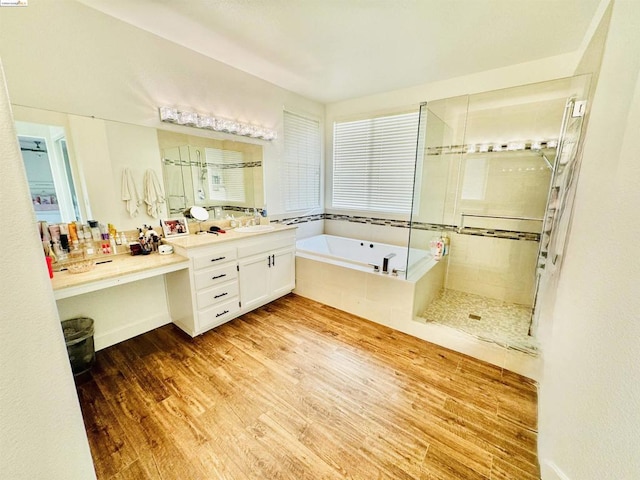 bathroom with hardwood / wood-style floors, vanity, and shower with separate bathtub