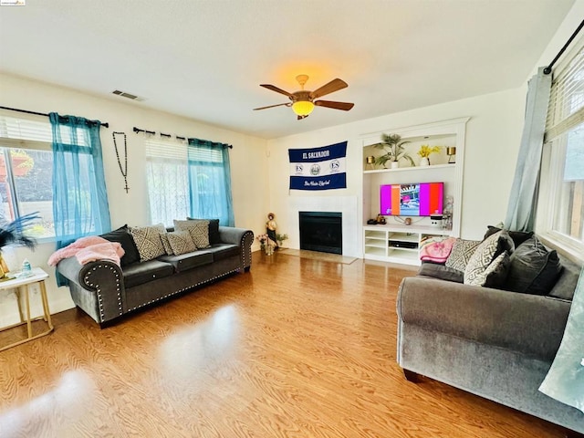 living room featuring wood-type flooring and ceiling fan