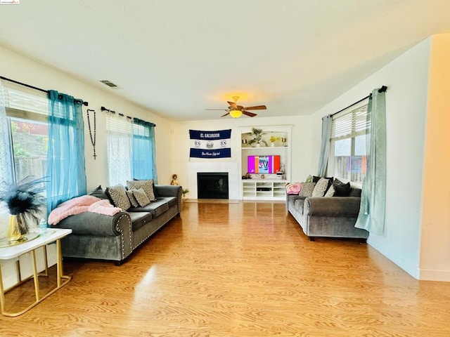 living room featuring light wood-type flooring and ceiling fan