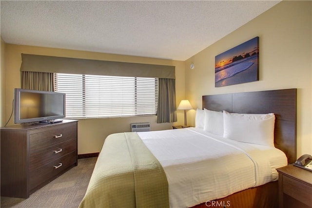 bedroom with carpet flooring, a textured ceiling, and an AC wall unit