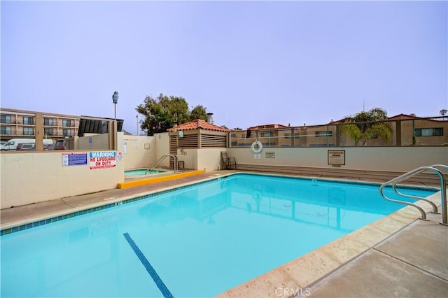 view of pool with a hot tub