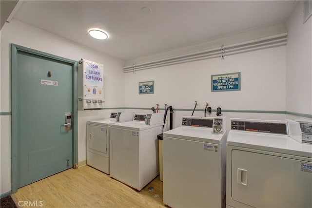 laundry area featuring washing machine and dryer and light wood-type flooring