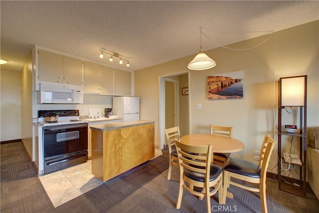 kitchen with decorative light fixtures, light tile patterned flooring, white appliances, and a textured ceiling