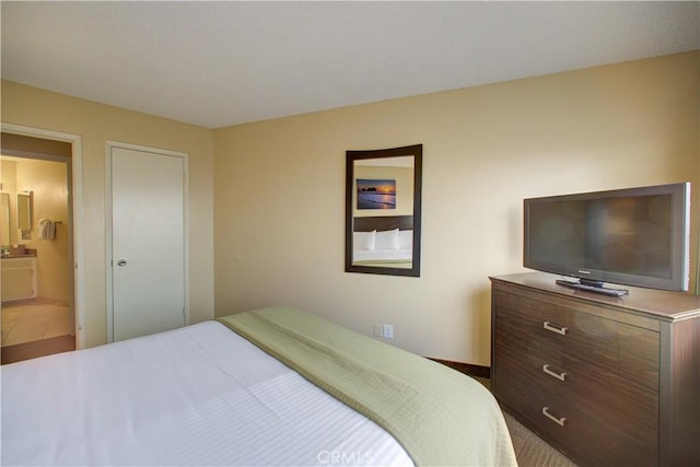 bedroom featuring tile patterned floors and ensuite bathroom