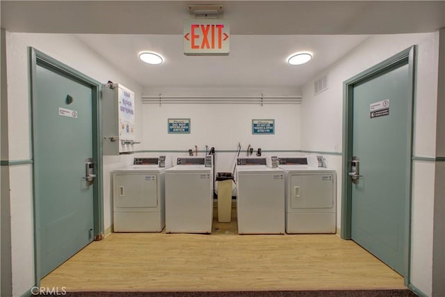 laundry area with light wood-type flooring and washing machine and dryer