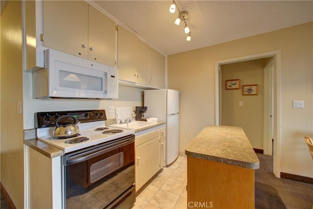 kitchen with a center island, sink, a textured ceiling, white appliances, and light tile patterned flooring