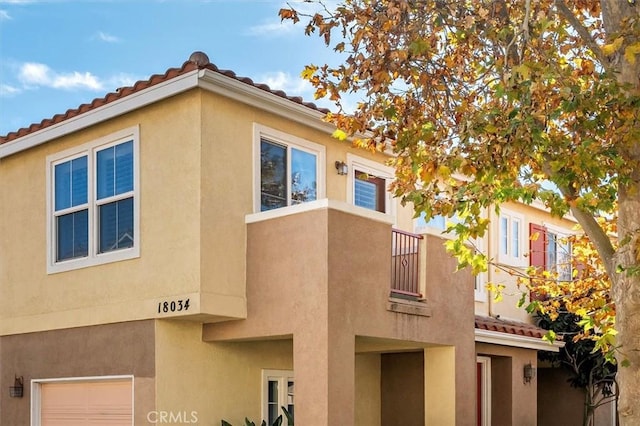 view of home's exterior featuring a garage and a balcony