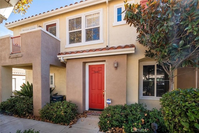 doorway to property with central AC unit and a balcony